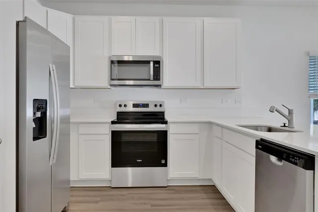 a kitchen with stainless steel appliances a stove microwave and refrigerator