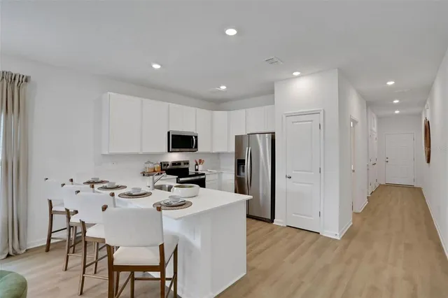 a kitchen with stainless steel appliances kitchen island granite countertop a refrigerator and a stove top oven