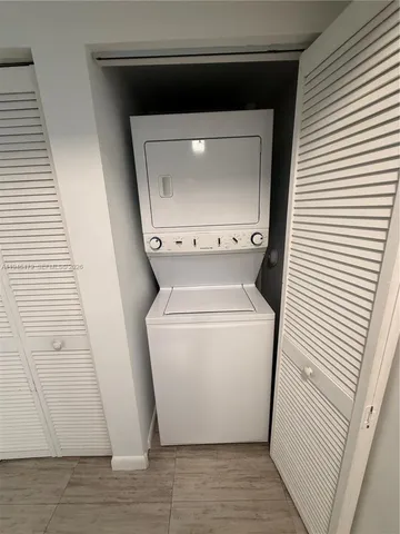 a utility room with wooden floor washer and dryer