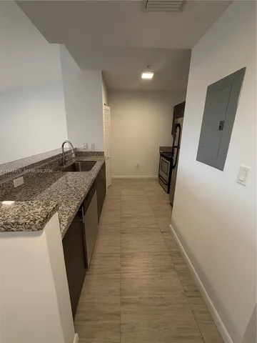 a kitchen with granite countertop a sink and a stove