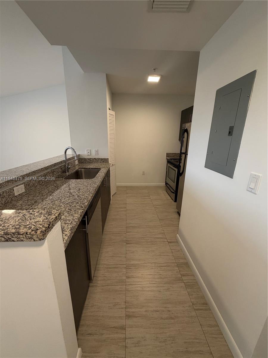 1801 Southwest 32nd Avenue, Unit 701 Miami, FL 33145 - Photo 5 of 13 a kitchen with granite countertop a sink and a stove