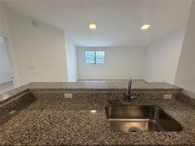 a kitchen with a sink and granite top