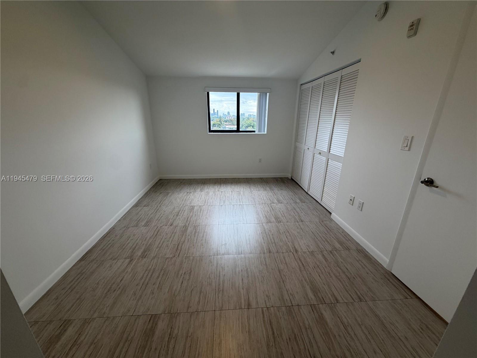 1801 Southwest 32nd Avenue, Unit 701 Miami, FL 33145 - Photo 9 of 13 an empty room with wooden floor and window