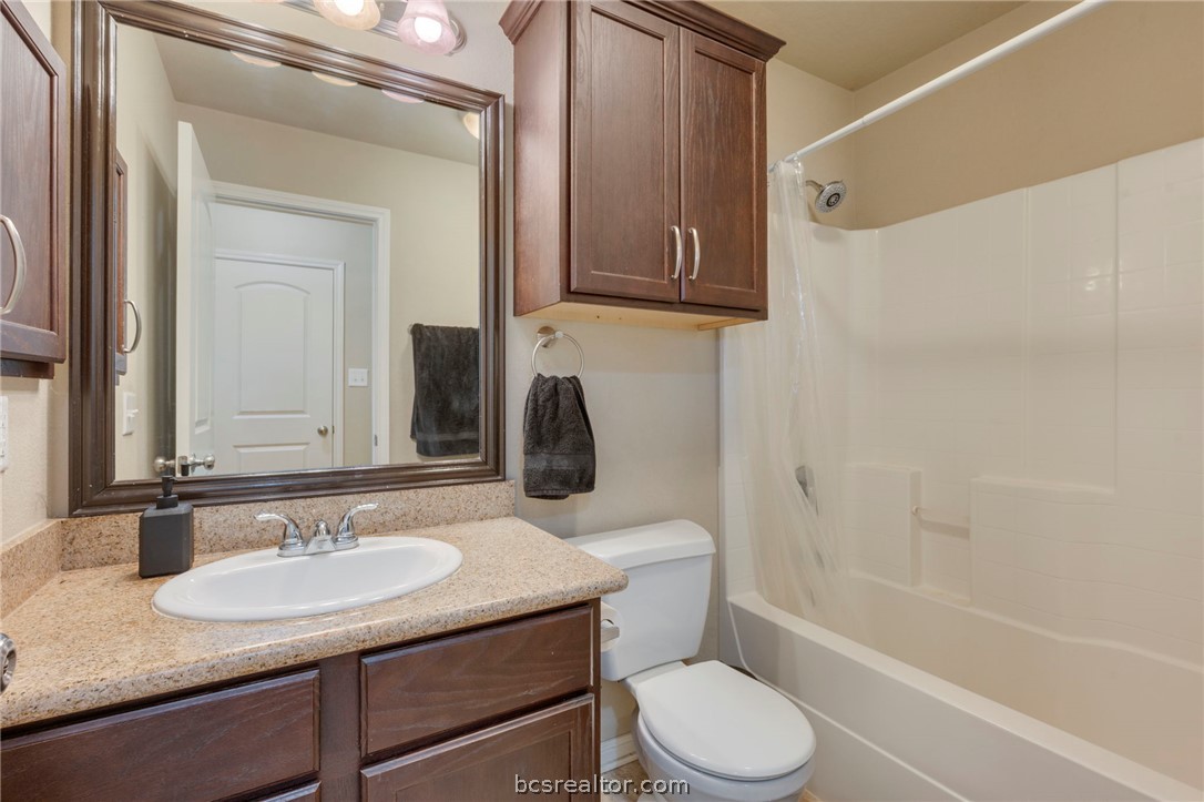 2000 Turning Leaf Drive Bryan, TX 77807 - Photo 12 of 20 a bathroom with a granite countertop sink toilet a mirror and shower