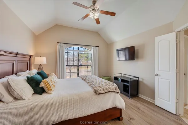 a bedroom with a bed a dresser and flat screen tv