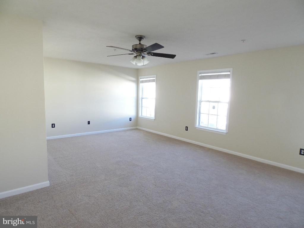 9705 Langley Road Baltimore, MD 21220 - Photo 12 of 26 an empty room with a window and a fan