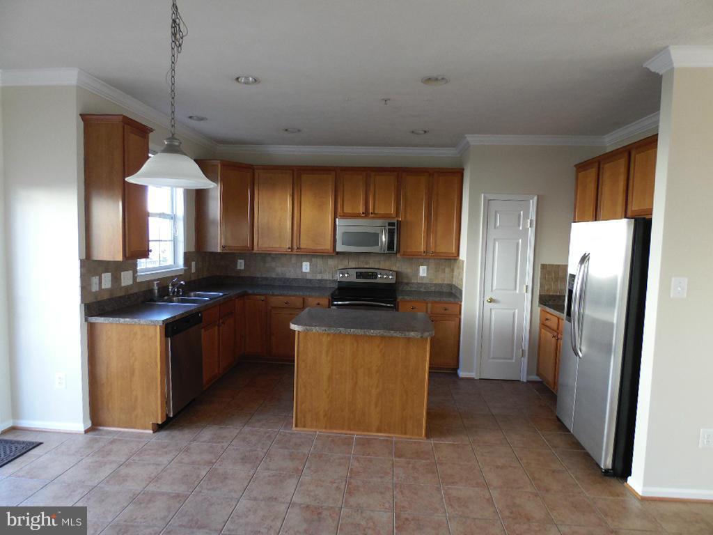 9705 Langley Road Baltimore, MD 21220 - Photo 4 of 26 a kitchen with stainless steel appliances granite countertop a refrigerator a sink a stove a microwave and island