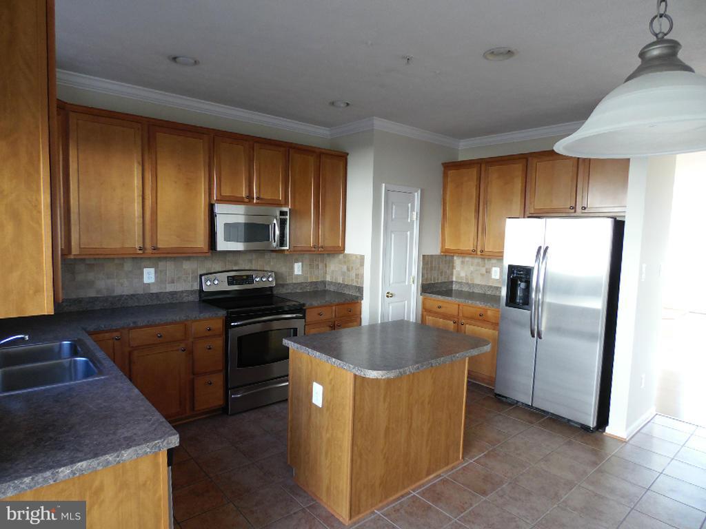 9705 Langley Road Baltimore, MD 21220 - Photo 5 of 26 a kitchen with kitchen island granite countertop a stove a sink a refrigerator and a oven