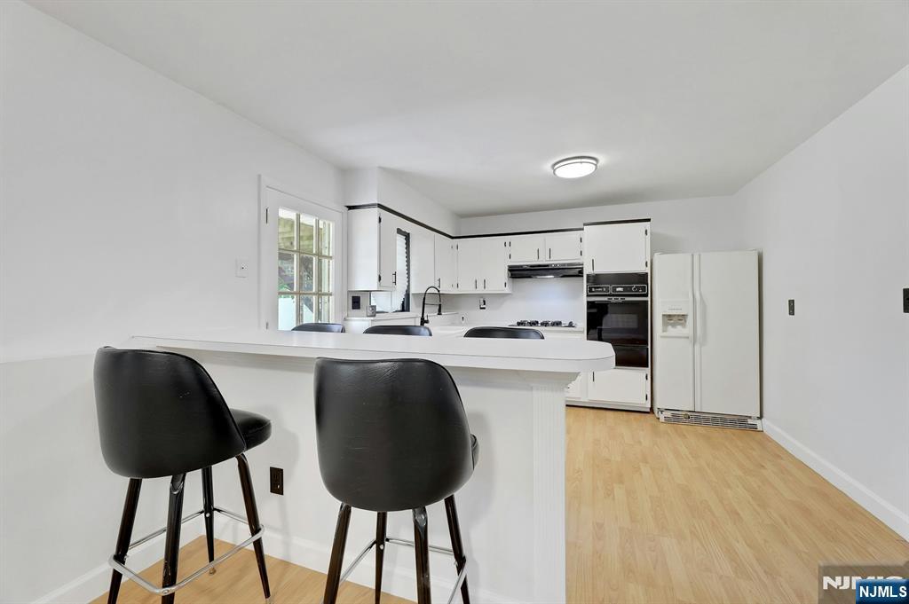 20 Blue Hill Road Norwood, NJ 07648 - Photo 33 of 49 a kitchen with stainless steel appliances kitchen island a table chairs in it and white cabinets