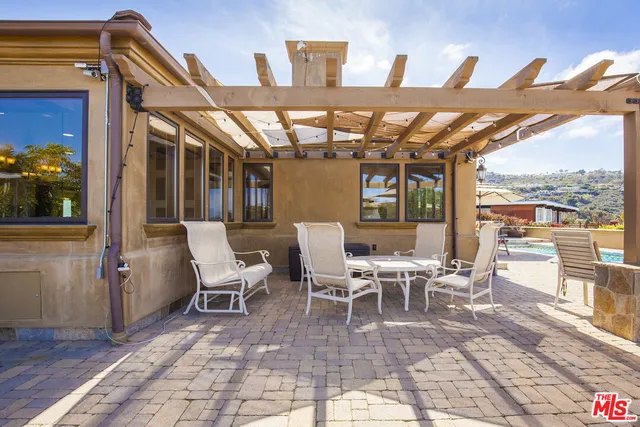 a view of a patio with dining table and chairs