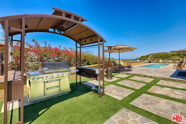 a patio with a table and chairs under an umbrella
