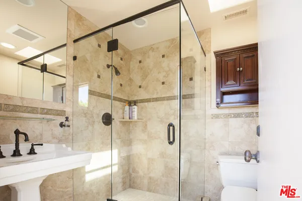 a bathroom with a granite countertop sink a toilet and shower