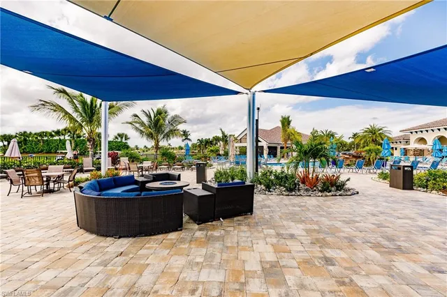 a view of a patio with couches and chairs under an umbrella