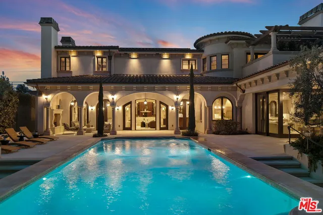 a view of a brick house with a small yard and large trees