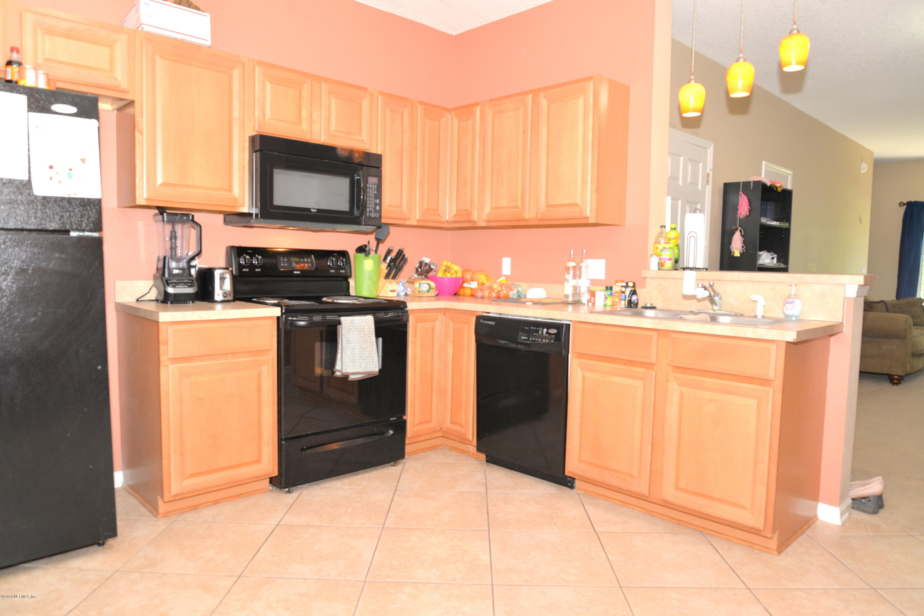 a kitchen with a sink a stove top oven and cabinetry