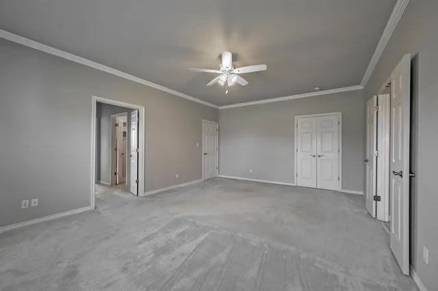 a view of an empty room with a ceiling fan