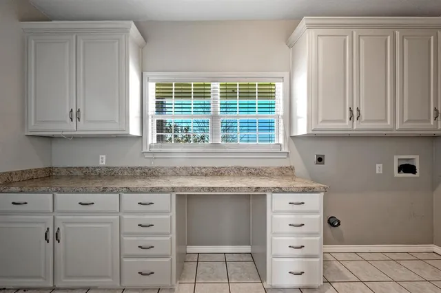 a kitchen with granite countertop cabinets and window