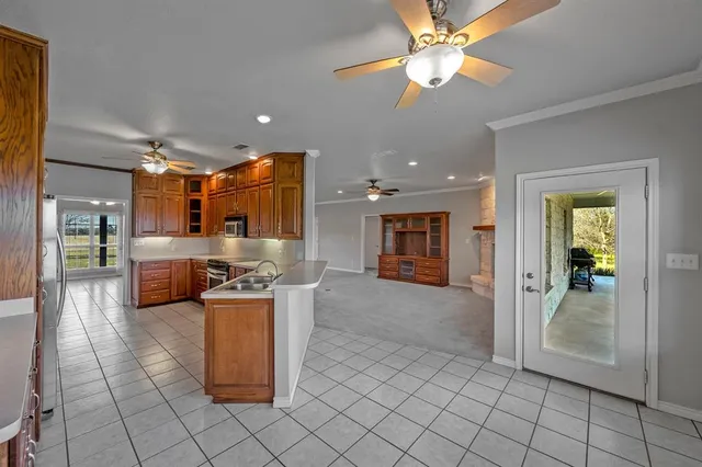 a open kitchen with stainless steel appliances granite countertop a refrigerator and a stove top oven