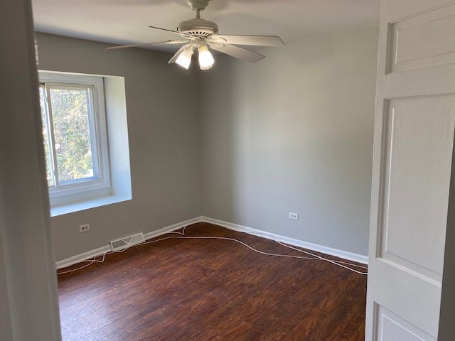 7037 West Main Street Niles, IL 60714 - Photo 13 of 29 an empty room with wooden floor fan and windows