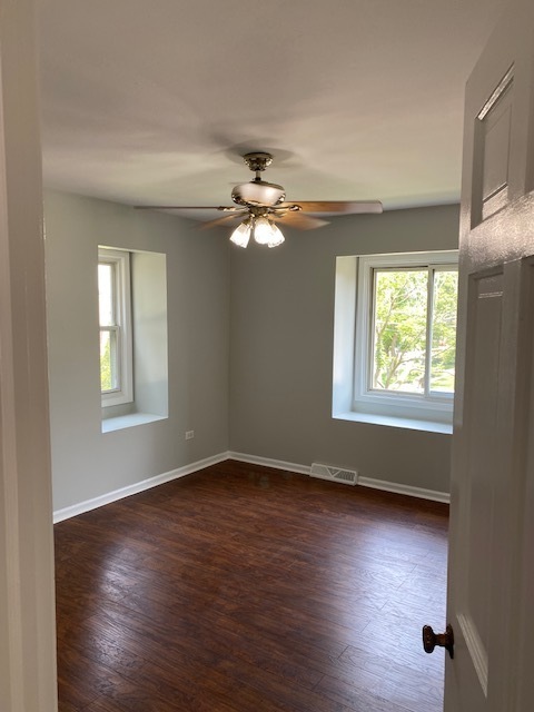 7037 West Main Street Niles, IL 60714 - Photo 20 of 29 an empty room with wooden floor chandelier fan and windows