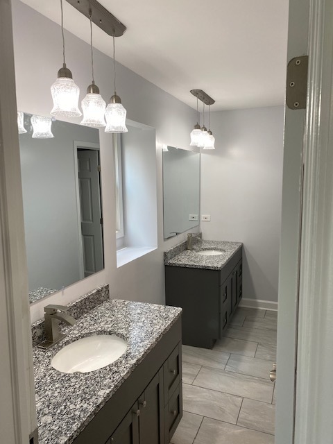 7037 West Main Street Niles, IL 60714 - Photo 22 of 29 a bathroom with a granite countertop sink and a mirror