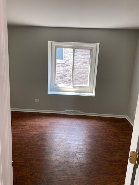 7037 West Main Street Niles, IL 60714 - Photo 27 of 29 an empty room with wooden floor and windows
