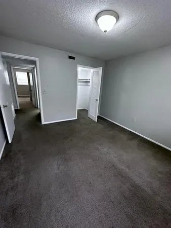 an empty room with closet and windows
