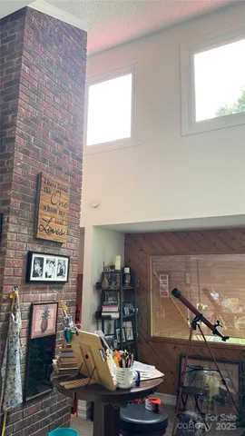 a living room with furniture a fireplace and a large window