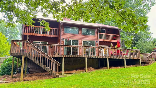 a view of a house with a deck and a yard