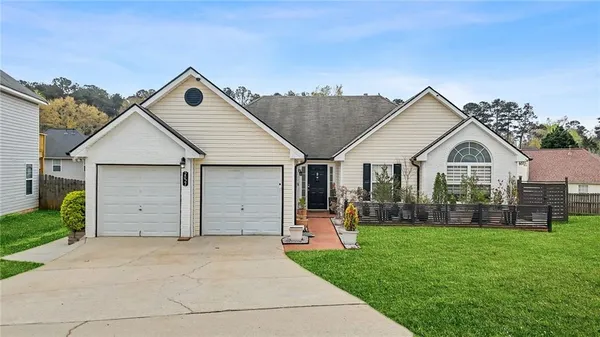 a view of a white house with a yard and garage