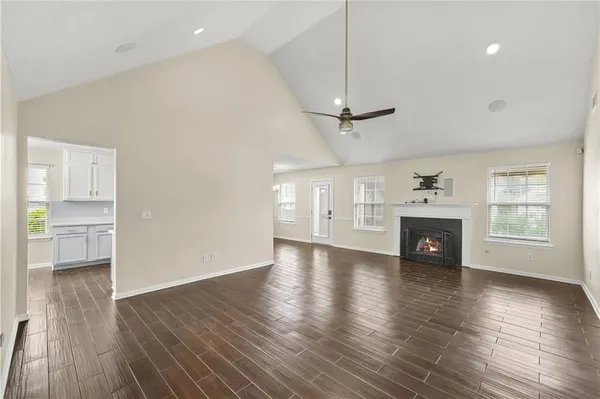a view of empty room with wooden floor fireplace and windows
