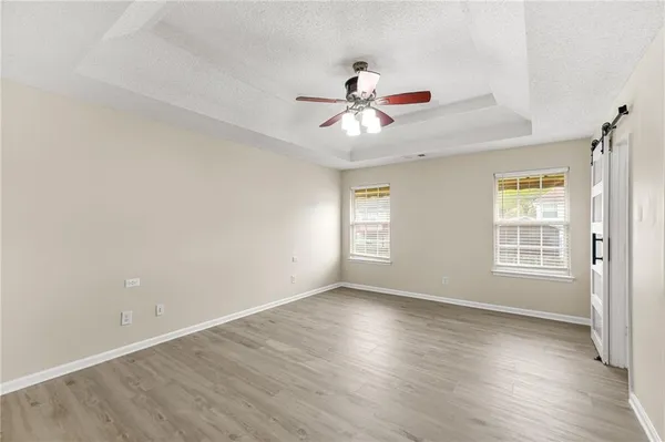a view of an empty room with a window and wooden floor