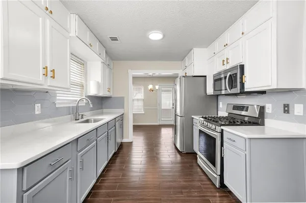a kitchen with stainless steel appliances granite countertop a sink stove and cabinets
