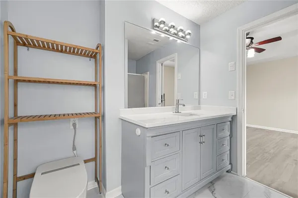a bathroom with a granite countertop sink a toilet and a mirror