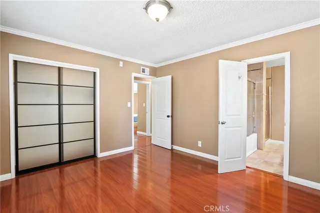 a view of an empty room with wooden floor