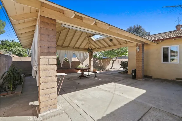 a view of a patio with a table and chairs under an umbrella
