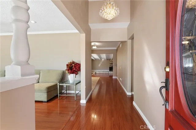 a hallway with a dining table a chandelier and a mirror