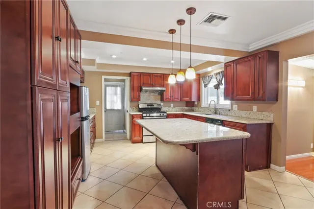 a kitchen with stainless steel appliances granite countertop a sink and a refrigerator