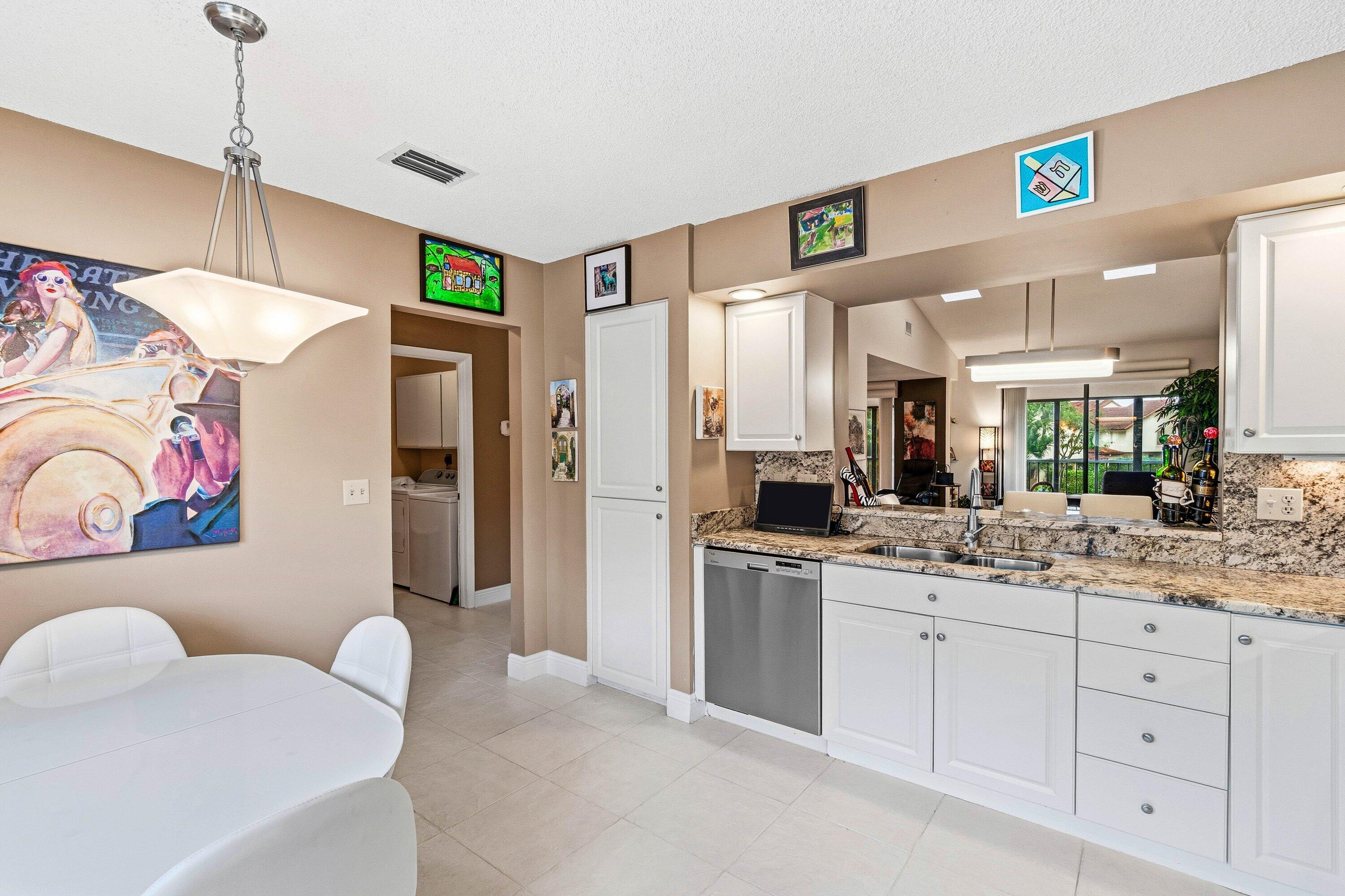 7759 La Mirada Drive Boca Raton, FL 33433 - Photo 9 of 37 a kitchen with stainless steel appliances kitchen island granite countertop a refrigerator and a sink