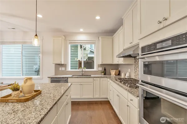 a large kitchen with granite countertop a stove and a sink