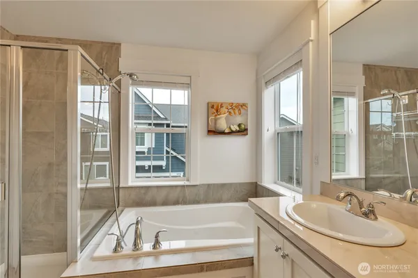 a bathroom with a tub a sink and a window