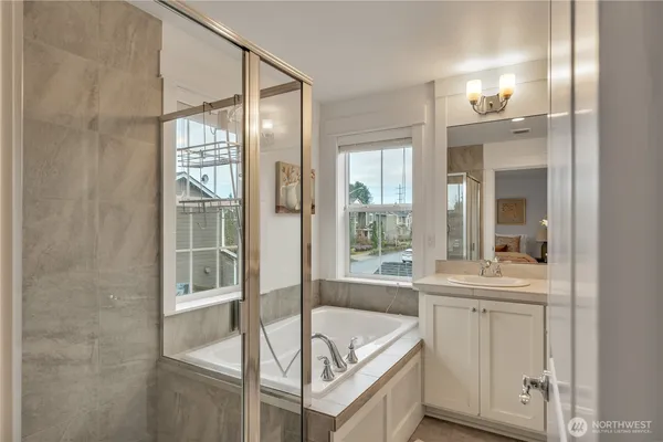a bathroom with a tub sink and mirror