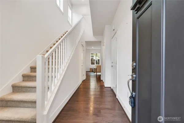 a view of a hallway with wooden floor and entryway