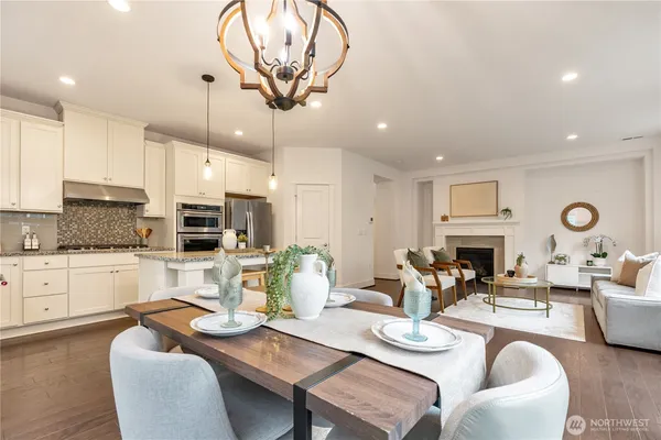 a view of a dining room with furniture a kitchen and chandelier