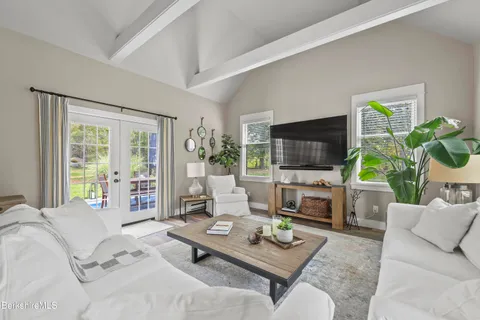 a living room with furniture a flat screen tv and a large window