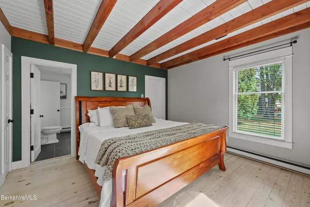 a bed sitting in a bedroom next to a window