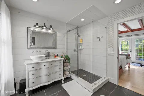 a bathroom with a double vanity sink mirror and shower