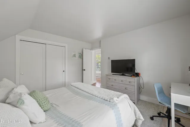 a bedroom with a bed and a flat screen tv