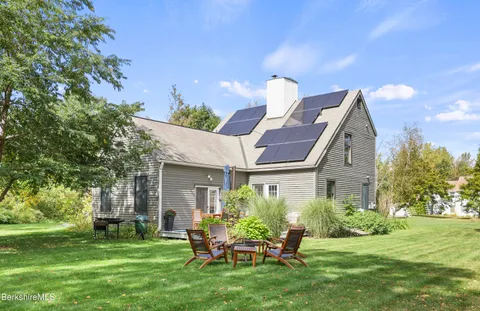 a backyard of a house with a garden and barbeque oven