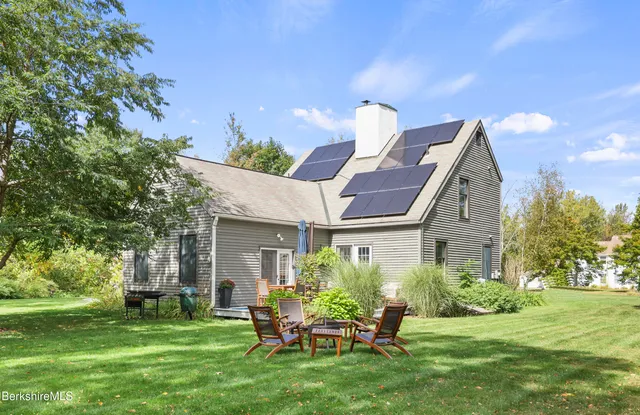 a backyard of a house with a garden and barbeque oven